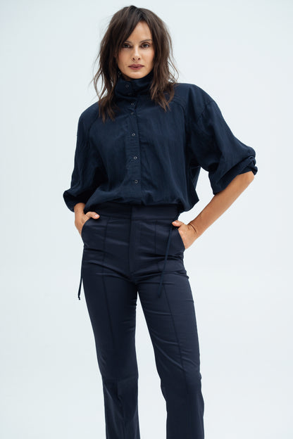 Model wears navy Enzy Pants and Nume shirt by Resident Stranger.